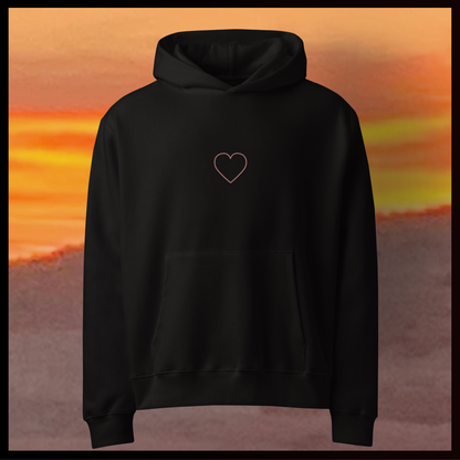 Black hoodie with a heart design on a desert at sunset